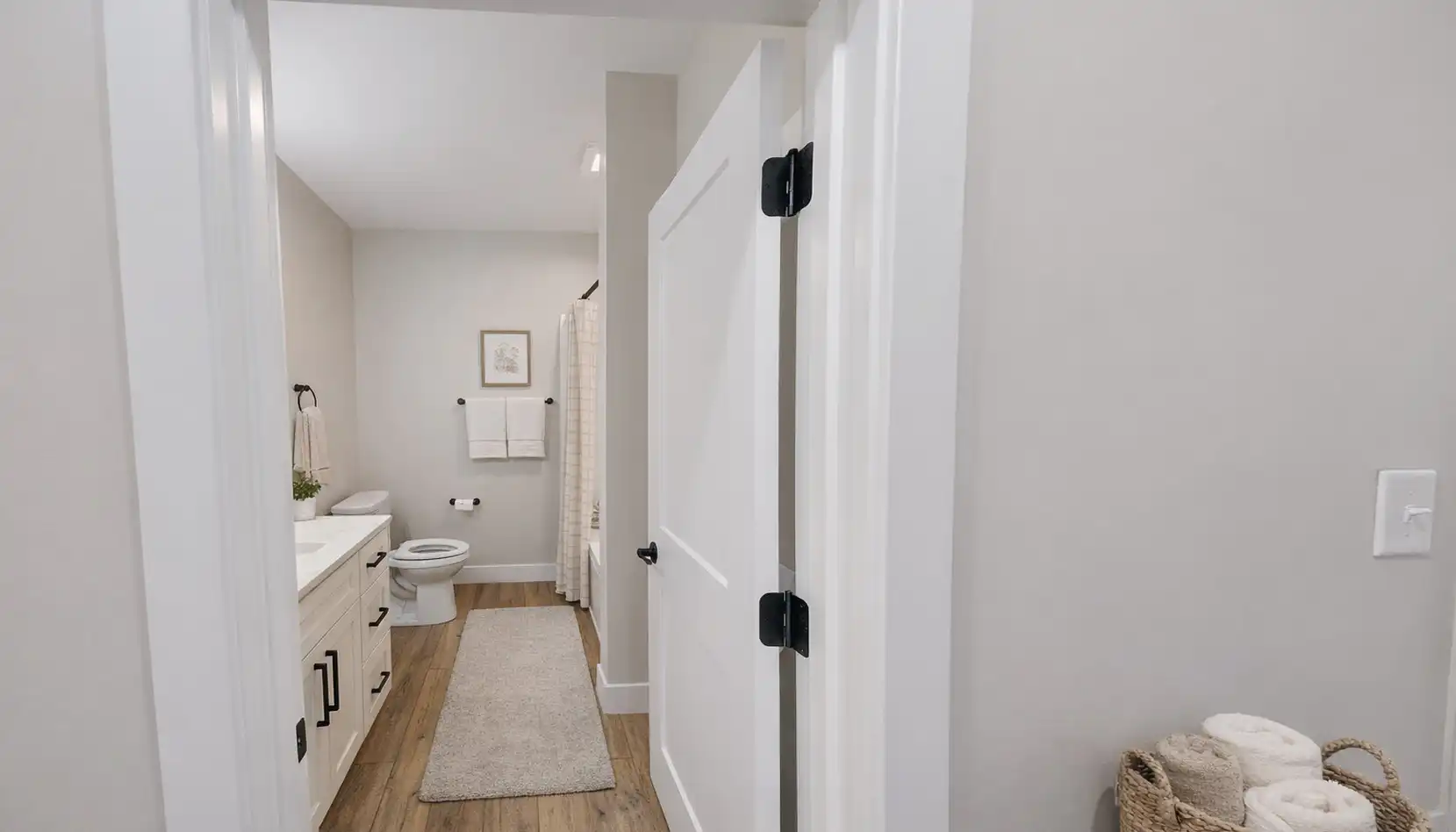 Leo-inspired modern bathroom with white vanity, black hardware, neutral decor, and striped shower curtain.