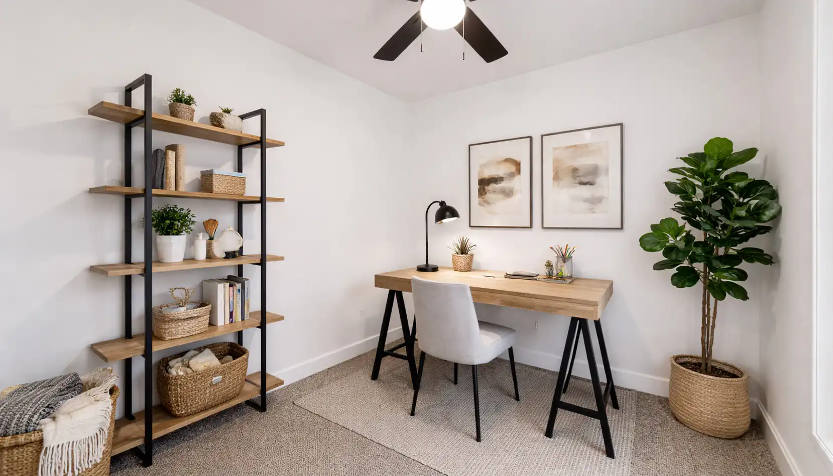 Minimalist Leo home office with warm wood desk, black shelving, woven baskets, and lush plants.