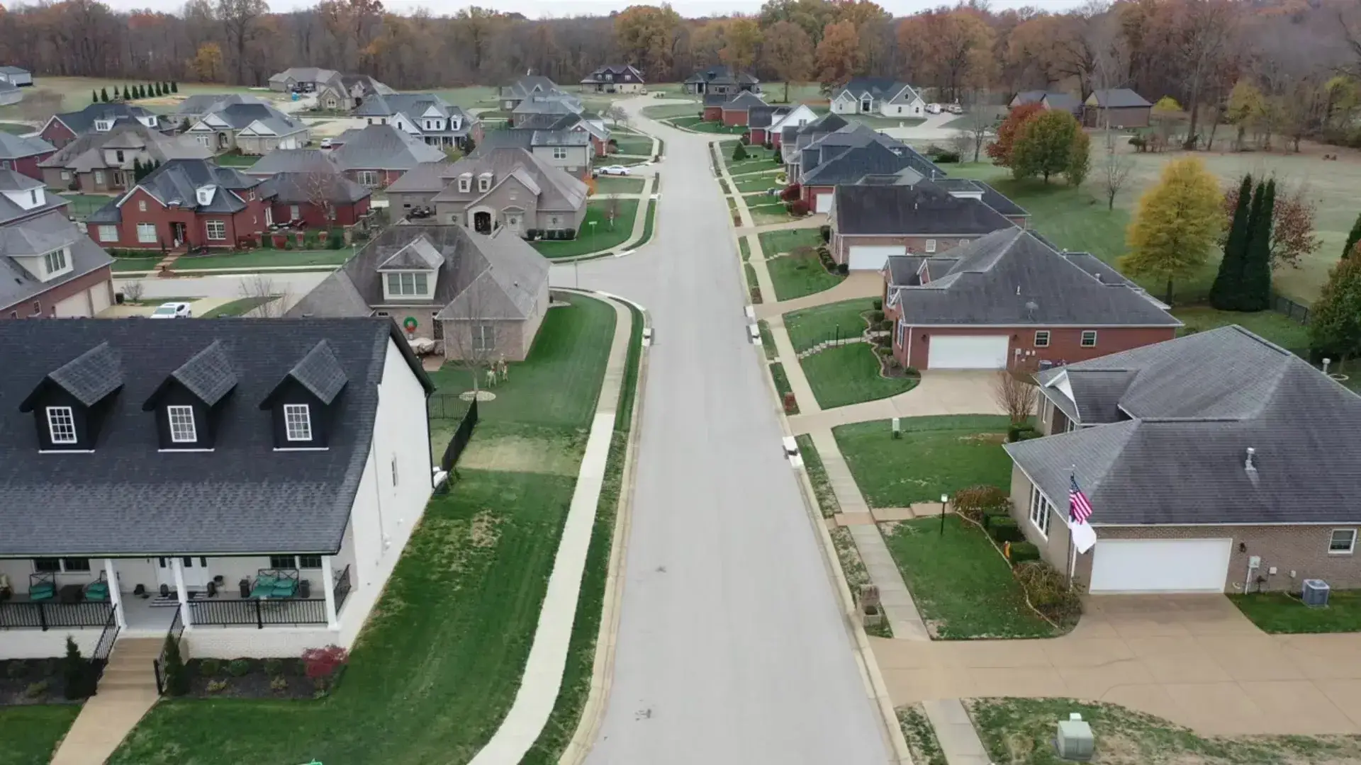 Aerial view of a new Evansville, Indiana subdivision with brick homes, landscaped lawns, and quiet streets.