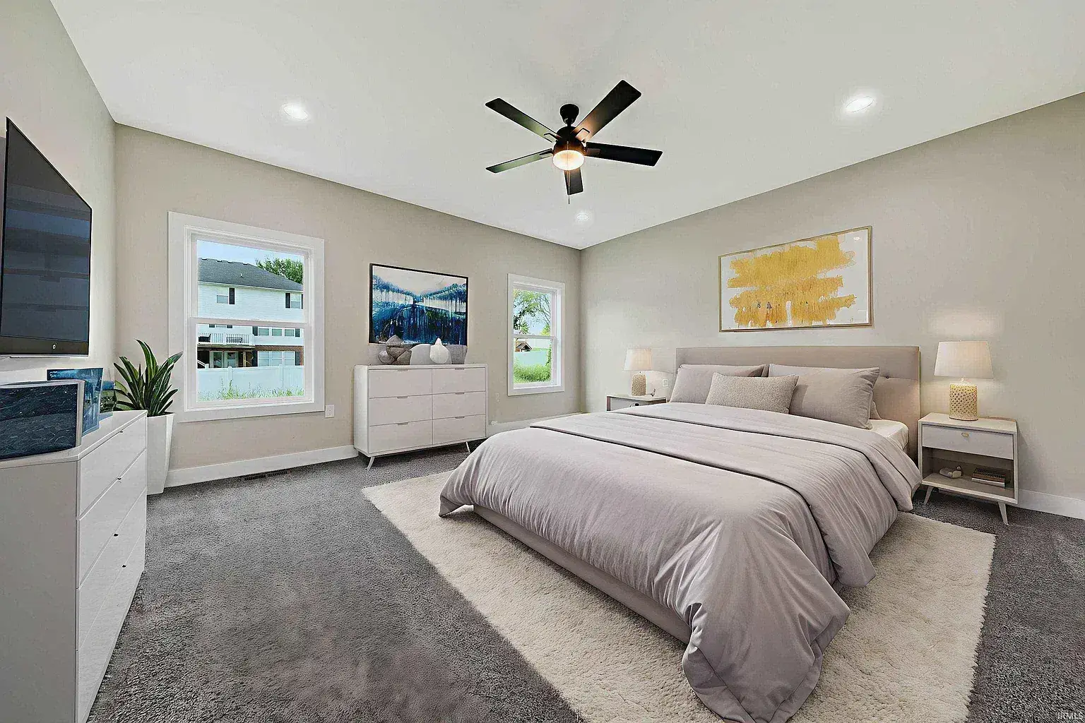 Modern bedroom design trends with vaulted ceiling, upholstered bed, gray carpet, and abstract art.