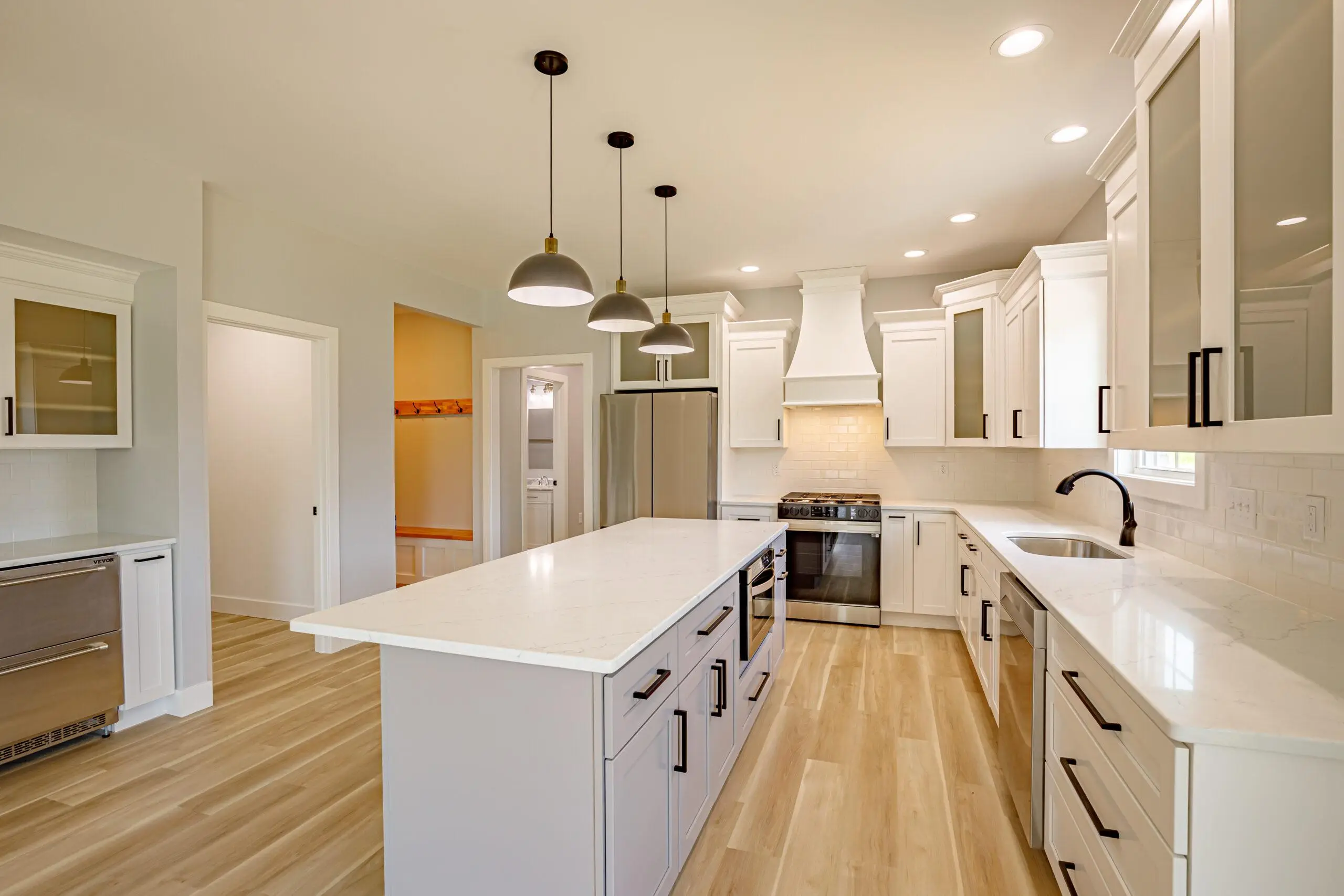 Move-in-ready Evansville home kitchen with white cabinets, stone island, and stainless steel appliances.