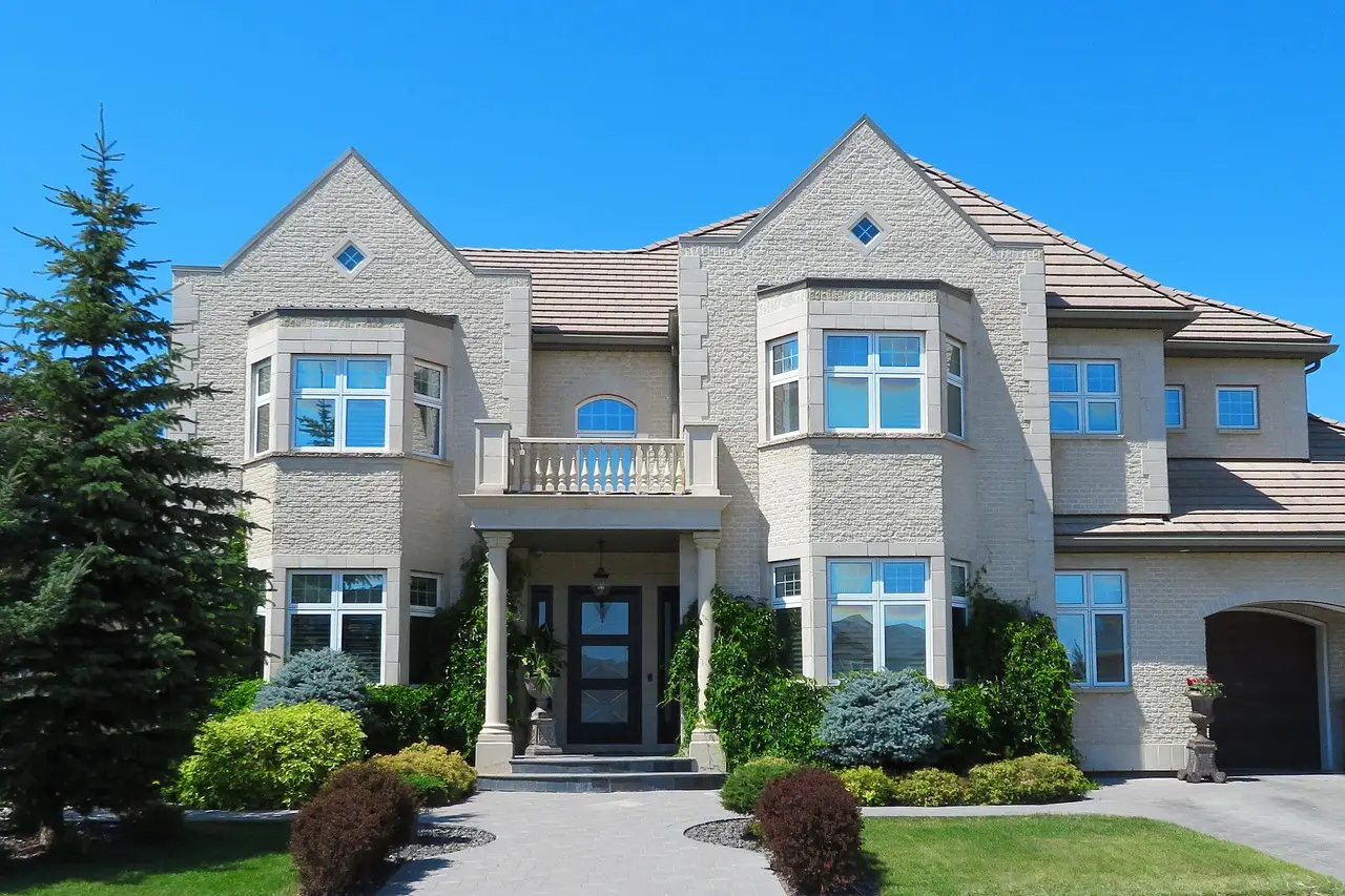 Two-story beige stone home showcasing a family-friendly new construction floor plan.