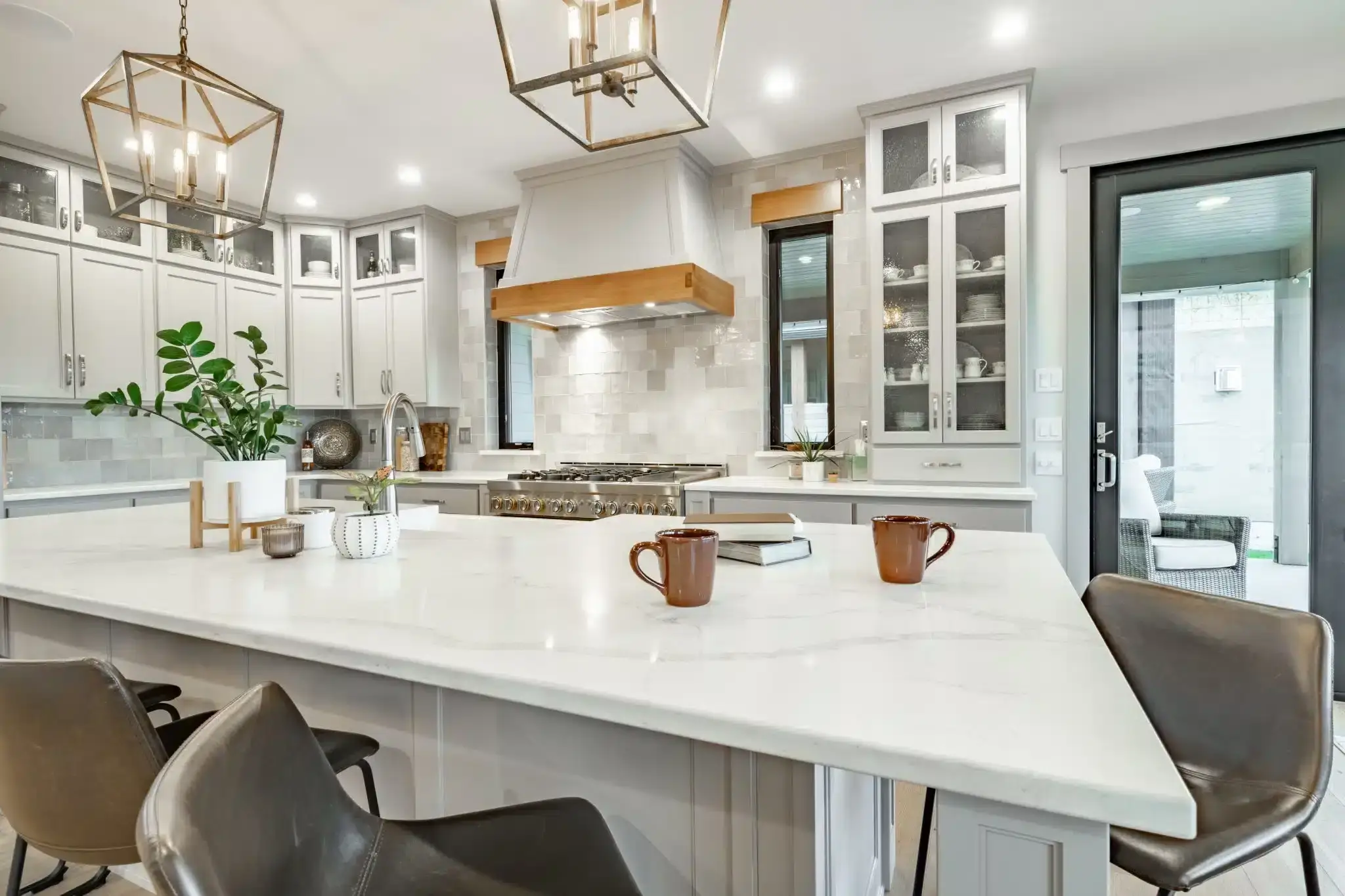 Modern new construction kitchen with marble island, custom gray cabinets, and stainless steel range.